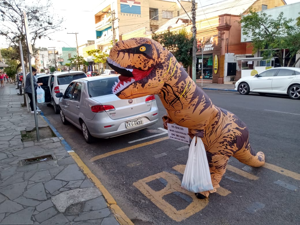 Para driblar desemprego, professor adere à fantasia de dinossauro e investe em venda de balas