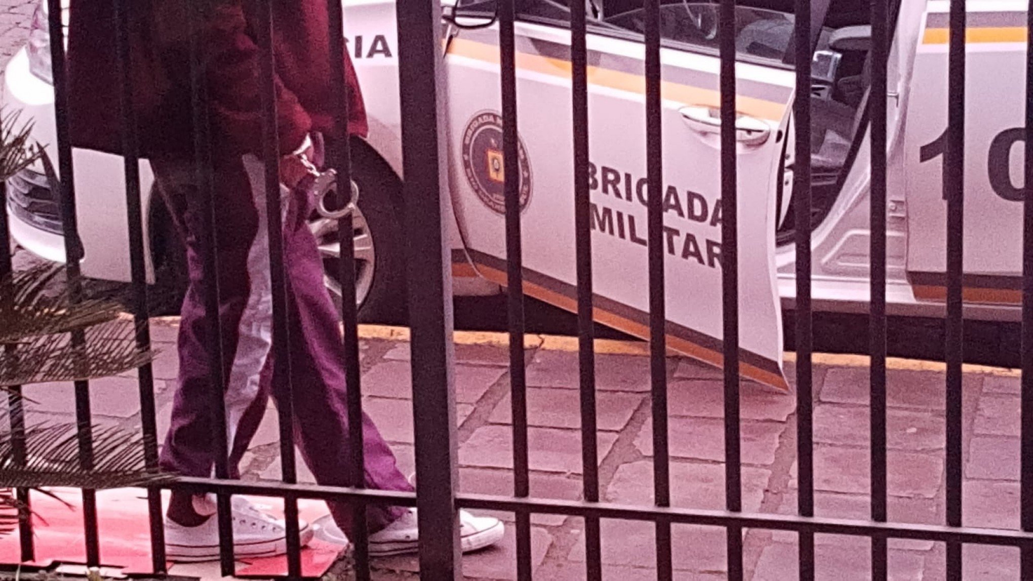 Preso é algemado em grade na calçada devido ao excesso de lotação das celas na delegacia de Taquara