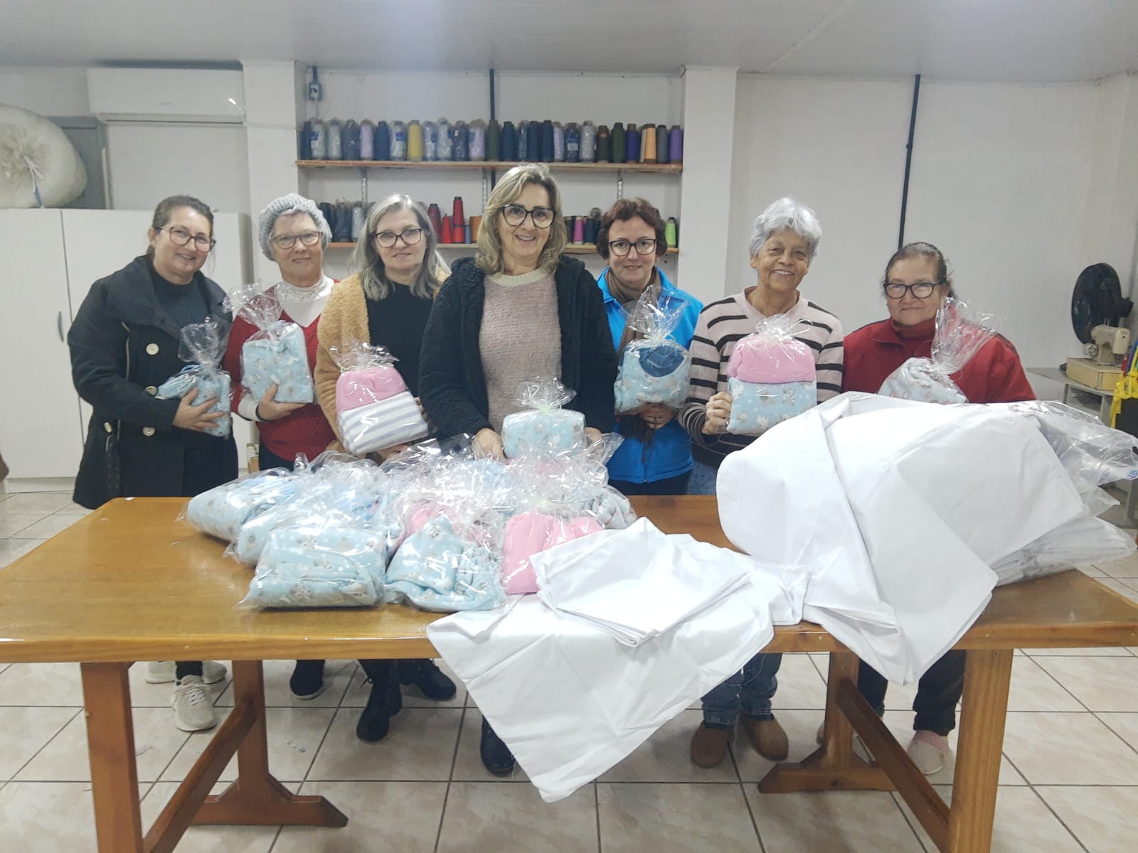 Grupo de Costura entrega lençóis e fronhas para hospital e roupas de bebê para famílias em Rolante